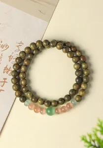 Elegant close-up of green sandalwood bead bracelet with natural cat's eye stone detail