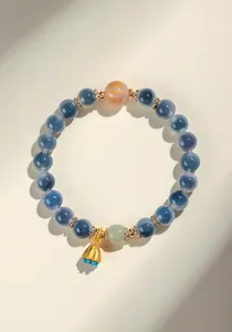 Dettaglio del braccialetto in agata con perla incisa e ciondolo a forma di loto.