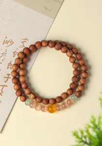 Close-up of a natural green sandalwood prayer bead bracelet with translucent gemstones