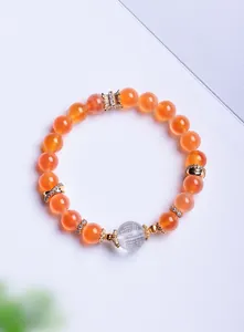 Détail macro de la gravure du Sutra du Cœur sur une perle de cristal et cornaline orange