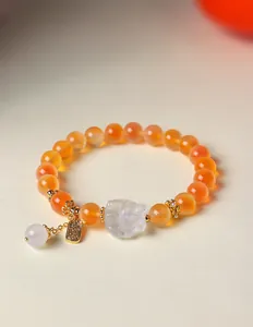 Detailansicht eines Armbands mit orangefarbenem Achat und einem Neunschwänzigen Fuchs.