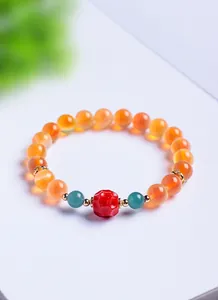 Vue rapprochée d'un bracelet en agate sucre translucide avec une perle centrale rouge
