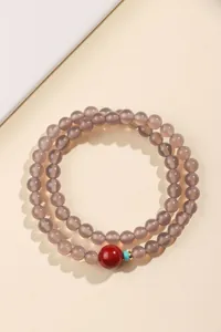 Detailweergave van dubbellaagse grijze agaat kralenarmband met rood accent
