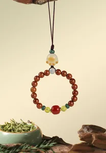 Macro view of Chinese style bodhi bead charm with jade cat paw and red agate accents