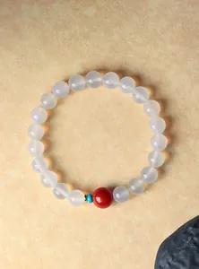 Detailweergave van doorschijnende witte agaat kralenarmband met rode accentkraal