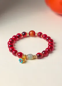 Vista dettagliata di un bracciale in agata rossa stile cinese con perla di giada e loto.