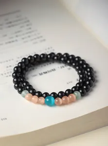 Detailed close-up of sandalwood beaded bracelet with blue cat's eye and aventurine