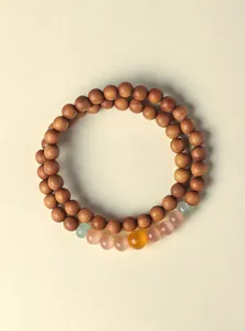Macro detail of natural sandalwood beads and colorful translucent cat's eye stones