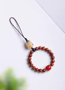 Detailed view of a handmade Chinese style Maneki-neko wooden bead charm for bags