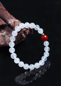 Detailweergave van een witte agaat kralenarmband met een prachtige rode accentkraal.