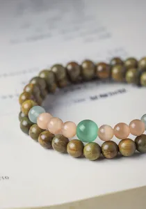 Detailed macro shot of natural green sandalwood beads and cat's eye stone bracelet