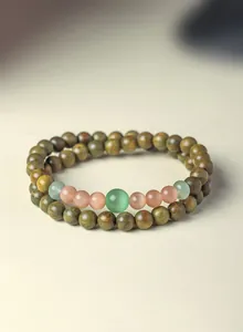 Detailed view of handmade green sandalwood bracelet with cat's eye gemstone beads