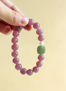 Κοντινό πλάνο βραχιολιού από μωβ χαλαζία με μενταγιόν από πράσινο νεφρίτη