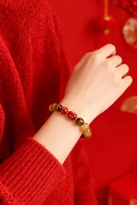 Bracelet en perles d'agate rouge et multi-gemmes porté au poignet pour la chance du zodiaque.