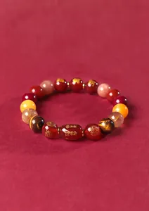 Gros plan d'un bracelet en agate rouge avec des symboles spirituels gravés en or
