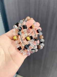 Detailaufnahme von Bergkristall und Rutilquarz Armbändern mit Sandelholzperlen