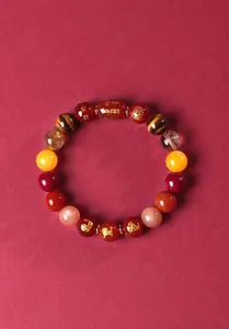 Vue détaillée d'un bracelet de zodiaque en agate rouge avec amulettes gravées.