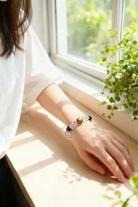 Nahaufnahme eines Perlenarmbands mit Bergkristall und Adlerholz am Handgelenk