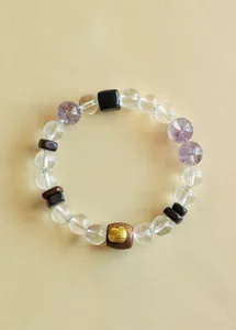 Detailansicht eines Armbands mit Bergkristall, Amethyst und edlen Sandelholzperlen.