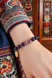 Detail eines Armbands im neuen chinesischen Stil mit Herzstein und Goldanhänger