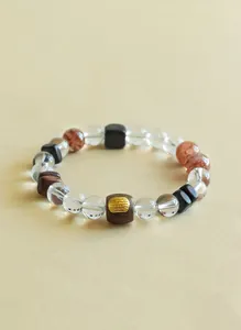 Makrodetail eines handgefertigten Perlenarmbands mit Bergkristall und gravierter Adlerholzperle.