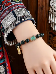 Detail eines chinesischen Perlenarmbands mit Jadewebart und Goldanhänger