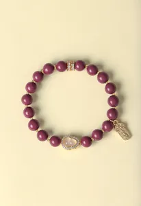 Nahaufnahme eines lila Duftperlenarmbands mit goldenem Flaschenkürbis und Glücksbringer.