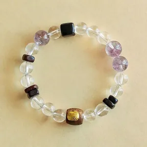Elegantes Perlenarmband aus Bergkristall und Amethyst mit Adlerholz-Akzenten und Schrift
