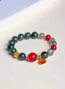 Nahaufnahme eines handgefertigten Armbands aus Naturstein mit rotem Achat und grünem Quarz.