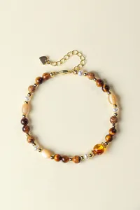 Luxe detailweergave van tijgeroog en zoetwaterparel armband met gouden hartbedel