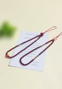 Detail view of elegant garnet beaded bag charms featuring colorful natural stone accents