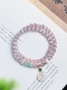 Detailansicht eines Lavendel-Katzenaugen-Armbands mit weißem Jade-Donut-Anhänger