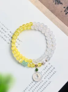 Exquisites Detail des zweireihigen Armbands mit gelben Katzenaugen-Perlen und Jade-Anhänger