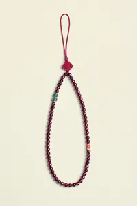Detail shot of a garnet beaded lanyard featuring a traditional Chinese knot and jade accents