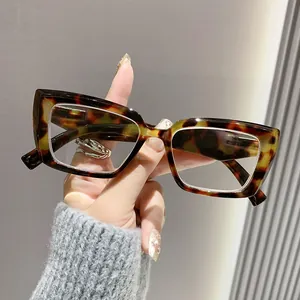 Nahaufnahme einer modischen quadratischen Lesebrille aus Schildpatt für Damen in der Hand