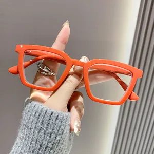 Detalle de gafas de lectura elegantes con montura gruesa naranja y lentes anti luz azul.