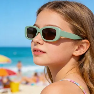 Nahaufnahme eines Kindes mit grüner Retro-Sonnenbrille für optimalen UV-Schutz am Strand