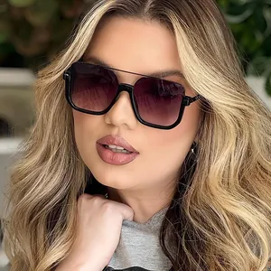 Close-up of woman wearing oversized square double-bridge sunglasses with purple lenses.