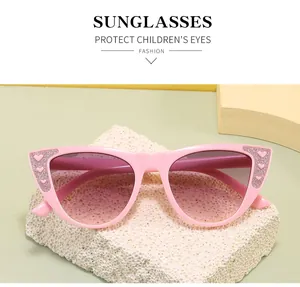 Detailansicht der pinkfarbenen Katzenaugen-Sonnenbrille für Kinder mit Glitzerherz-Akzenten.