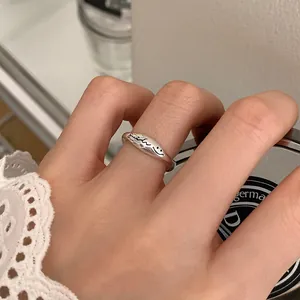 Detailansicht eines minimalistischen Silberrings mit eingraviertem Smile-Schriftzug
