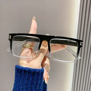 Close-up view of square reading glasses with black gradient frame held by a hand