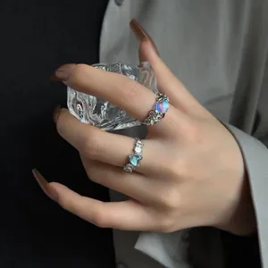 Detailed macro shot of heart-shaped moonstone and colored zircon rings on hand