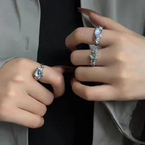 Detailed view of silver lava texture rings featuring heart-shaped moonstone on fingers