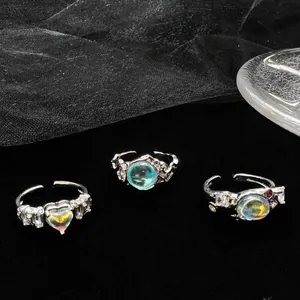 Detailed view of iridescent heart moonstone and zircon rings with lava texture.