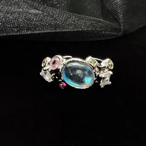 Close-up of moonstone and colored zircon stones on an irregular silver ring