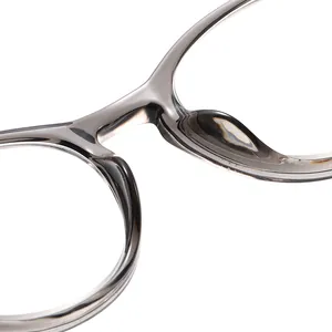Close-up detail of the bridge and nose pads of grey translucent reading glasses.