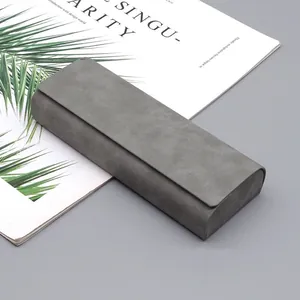 Vista detallada de un estuche para gafas de ante gris con diseño minimalista de solapa.