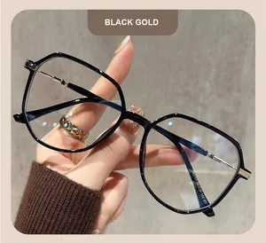Vista detallada de monturas de gafas poligonales grandes en negro y oro