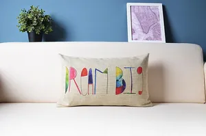 Nahaufnahme eines rechteckigen Leinenkissenbezugs mit buntem DREAM BIG Textaufdruck.