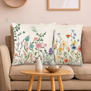 Frische Kissenbezüge mit Aquarell-Blumendruck auf einem Sofa für die Frühlingsdeko